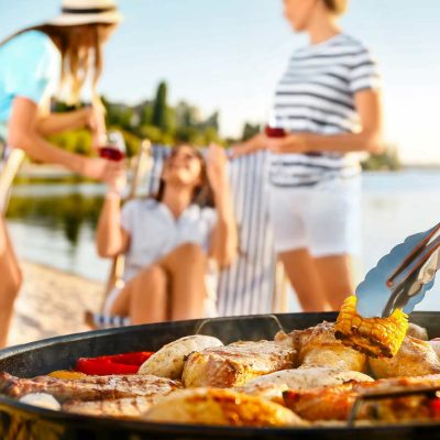 Grilling food at summer lakeside barbecue party