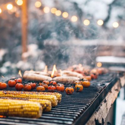 Winter barbecue with corn and tomatoes grilling.