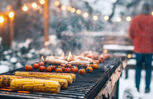 Winter barbecue with corn and tomatoes grilling.
